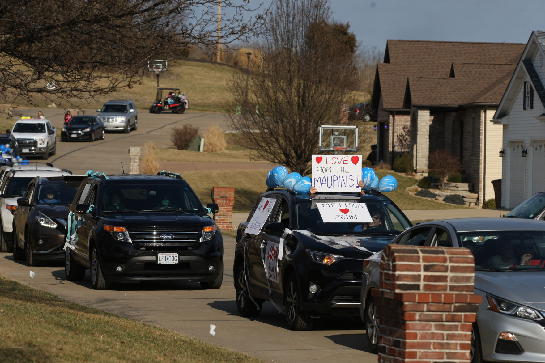 Cars parade past the Wilson home